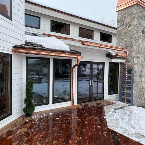 Copper K-style gutters and downspouts on a modern home in snowy weather in Salt Lake County, UT